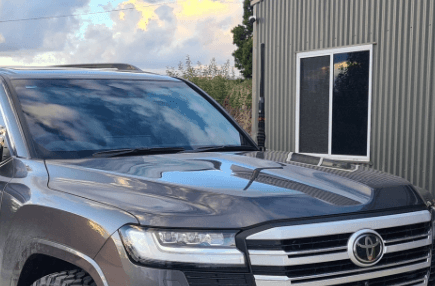 GMF4x4 BB-013D driver-side UHF antenna bonnet bracket for Toyota LandCruiser LC300 Series 2021-on, made from 5mm black powder-coated steel and bolting to factory bonnet hinge points without drilling.
